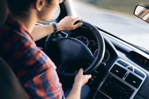 Free Close-up view of a man driving a modern car, showing dashboard and steering details. Stock Photo